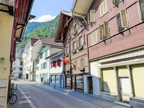 A street with buildings, a bicycle, and a person walking.