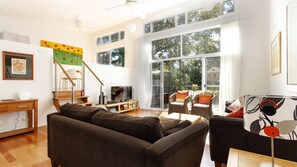 Relax in this stylish living room with a sofa, flat-screen TV, and sliding glass door leading to a balcony with outdoor views.