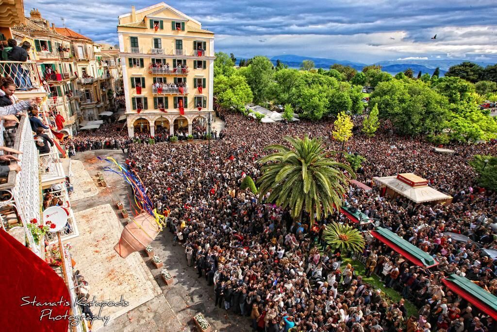 Une foule nombreuse s’est rassemblée dans un espace public en plein air, avec des bâtiments en arrière-plan.