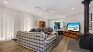 Una sala de estar moderna con un sofá, una televisión, una chimenea y una estantería.