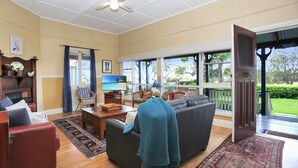 A spacious living room with a large TV, comfortable seating, and a view of the outdoors.