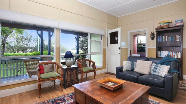 A living room with a sofa, two chairs, a coffee table, and a bookshelf.