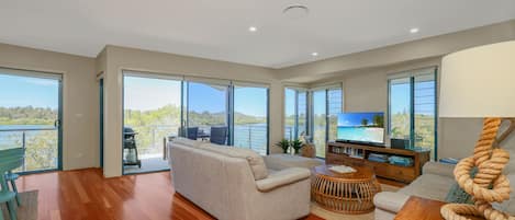 A spacious living room with a large sofa, a coffee table, and a television.