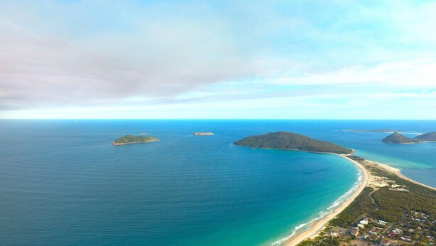 An aerial view of a coastal area with multiple islands and a beach. - Sandy Shores - Hawks Nest Holiday Home (Hawks Nest)