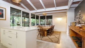 A modern kitchen with a dining area, large windows, and a ceiling with exposed beams. - Sandy Shores - Hawks Nest Holiday Home (Hawks Nest)
