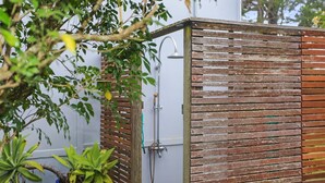 Una estructura de madera con ducha y manguera.