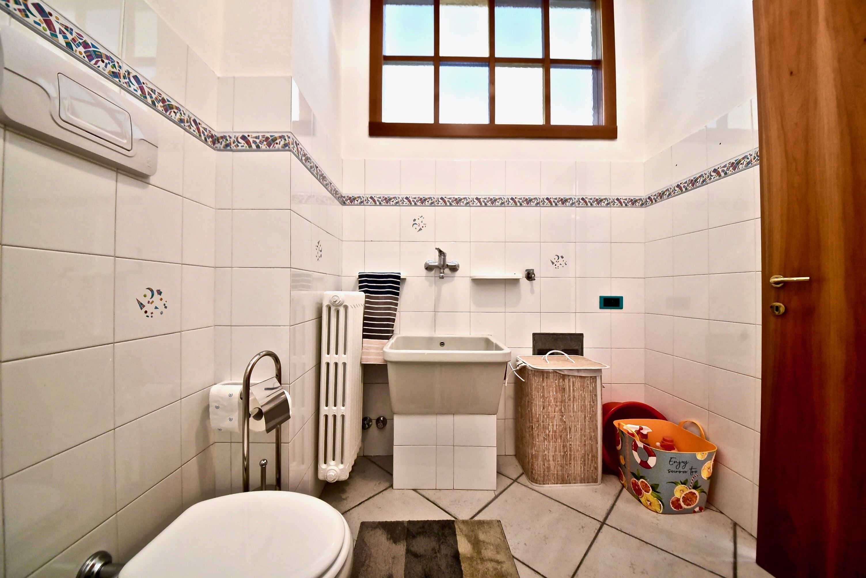 Ein kleines Badezimmer mit Toilette, Waschbecken und Heizkörper.