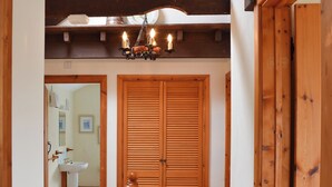 Una scala in legno conduce a una stanza con una porta in legno e un lampadario.