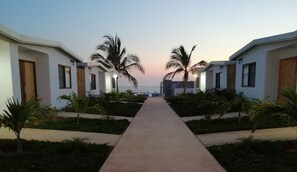 Ein Weg führt zu einem Strandhotel mit Palmen und freiem Blick auf den Ozean.