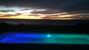 Una piscina iluminada con luz azul al atardecer.