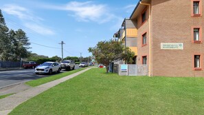 A building with a sign for Providence Apartments, a paved driveway, and parked cars.