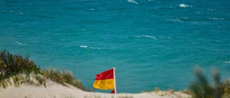 Eine Fahne an einem Mast am Meer.