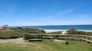 Une plage dotée d’une promenade en bois, d’une plateforme d’observation et offrant une vue dégagée sur l’océan.