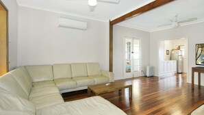 Un salon avec un canapé d’angle beige, une table basse en bois et un plancher en bois franc.