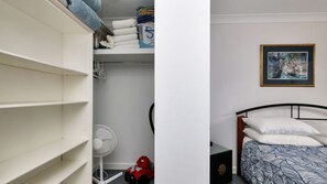 A bedroom with a bed, a nightstand, a fan, and a red toy car.