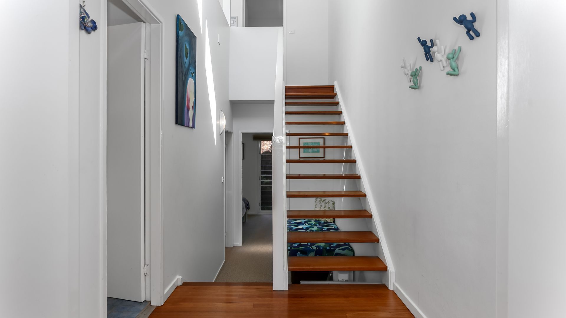 A staircase with wooden steps and a handrail, leading to an upper floor.