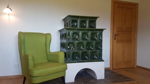 Une pièce avec un fauteuil vert, un meuble décoratif doté de plusieurs compartiments et une porte en bois.