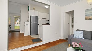 Un apartamento moderno con kitchenette, un sofá gris y vistas al exterior.