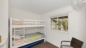 Una habitación con literas, una ventana con vistas y una silla.