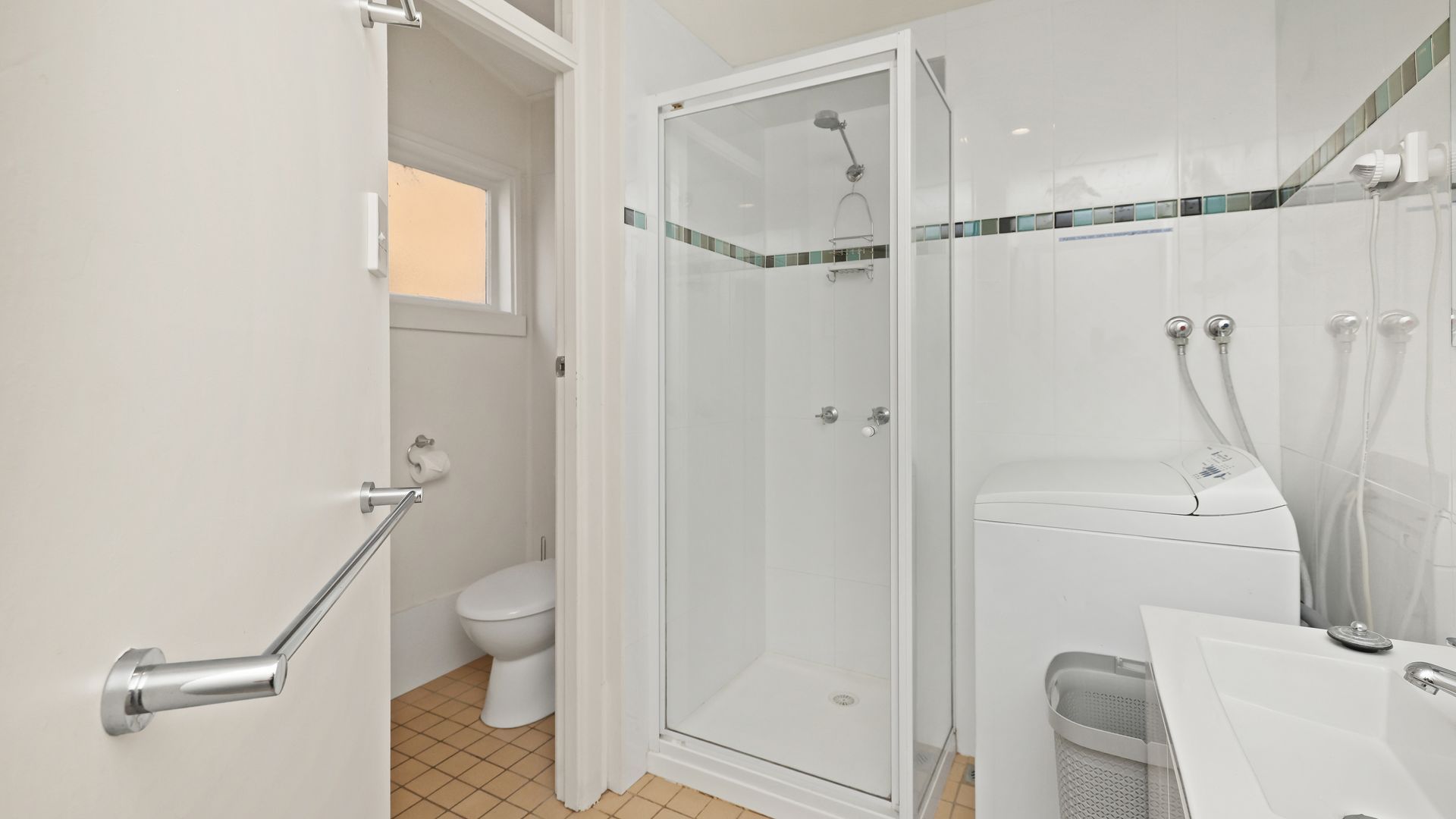 Een moderne badkamer met een douchecabine van glas, een toilet en een wastafel.