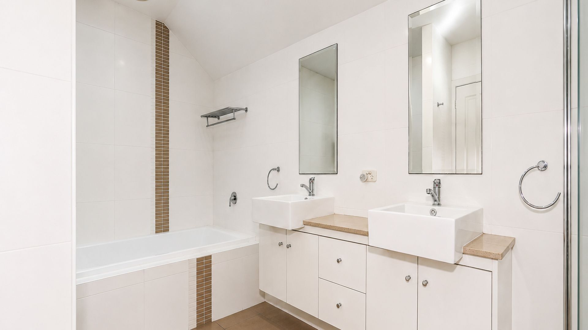 Une salle de bain moderne avec une baignoire, deux lavabos et un grand miroir.