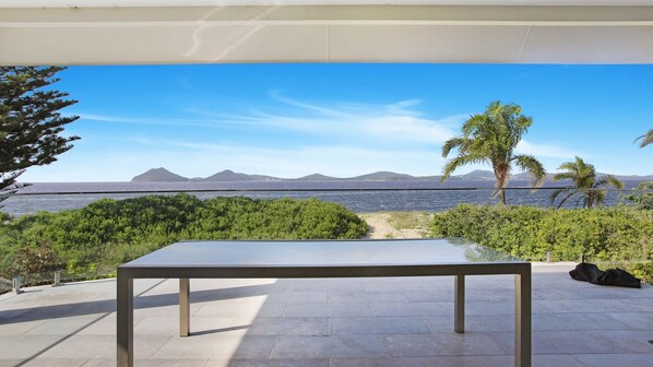 Une table installée dans un espace extérieur, offrant une vue sur la mer et les montagnes.