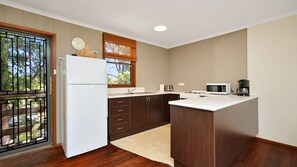 A kitchen with a refrigerator, microwave, toaster, and coffee maker. - Gumtree Cottage Hawks Nest (Hawks Nest)