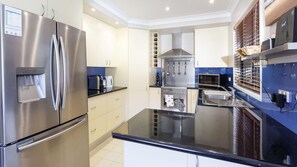 Prepare meals in the fully equipped kitchen with a refrigerator, stove, sink, and microwave.