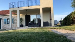 A modern two-story house with a balcony, a covered outdoor seating area, and a well-maintained lawn. - House with outdoor pool - Perfect for families! (Murvica)