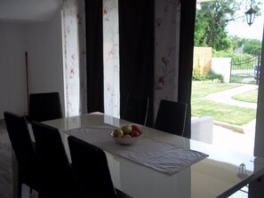 A dining table with a floral tablecloth, black chairs, and a bowl of fruit. - House with outdoor pool - Perfect for families! (Murvica)