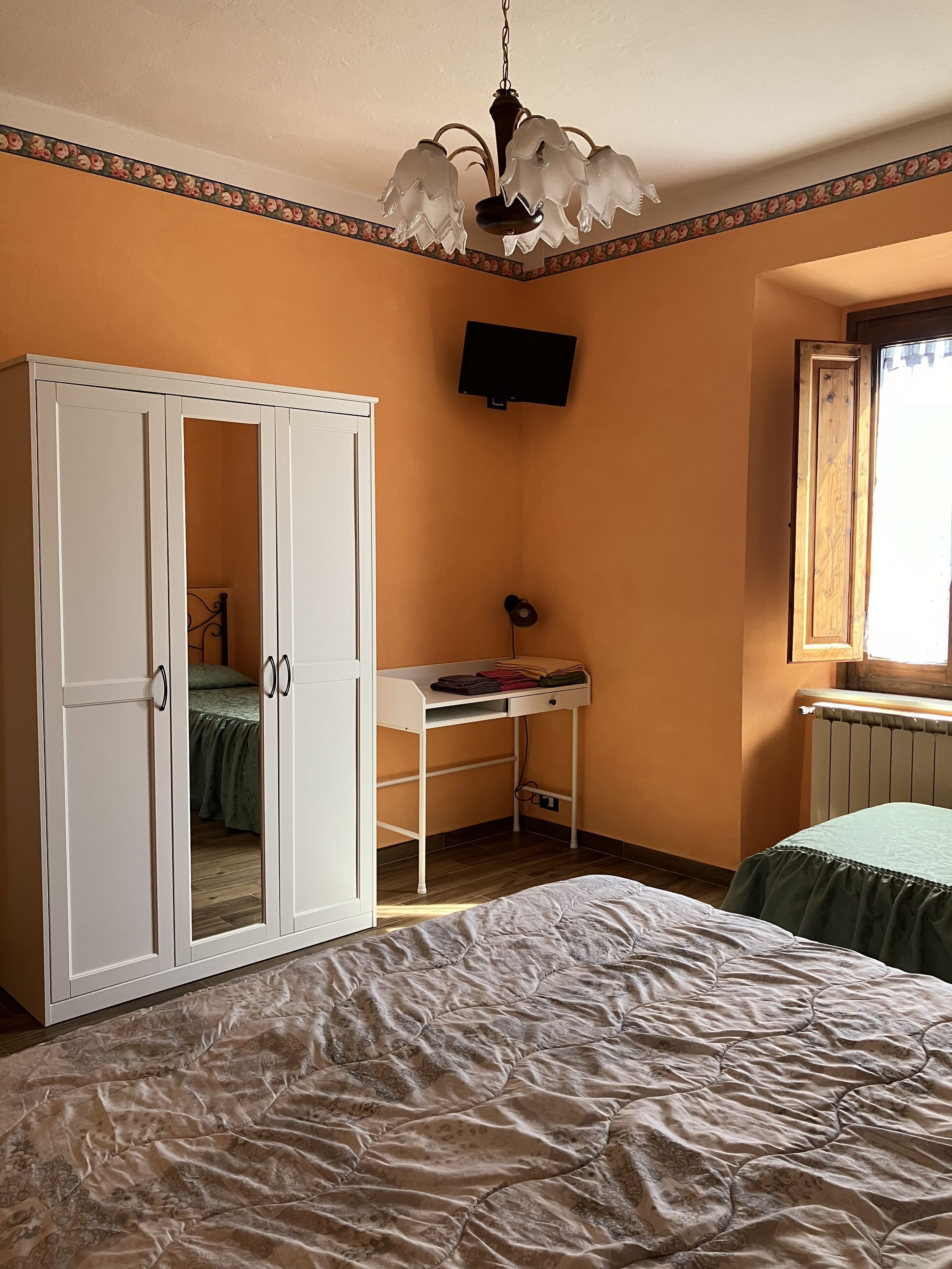 Une chambre à coucher comprenant un lit, une armoire, un bureau et un téléviseur.