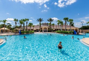 A large outdoor swimming pool with multiple lanes, surrounded by palm trees and lounge chairs. - Escape Villa (Kissimmee)