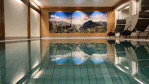 Une piscine ornée d’une fresque représentant des montagnes et d’une croix sur le mur.