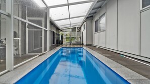 A swimming pool with a glass ceiling, surrounded by walls with large windows. - Bella on Boreen by Discover Stradbroke, 4 bed, 2 bath, contemporary beach house (Point Lookout)