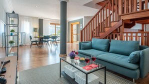 A modern living room with a blue sofa, a glass coffee table, and a wooden staircase. - 1. Villa Conde prívate pool,sea view & barbacue (Adeje)