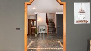 A hallway with a wooden archway leading to a staircase and a room with a tiled floor and a decorative rug. - 1. Villa Conde prívate pool,sea view & barbacue (Adeje)