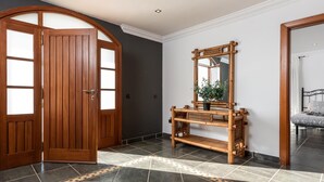 A room with a wooden door, a console table with a mirror, and a patterned floor. - 1. Villa Conde prívate pool,sea view & barbacue (Adeje)