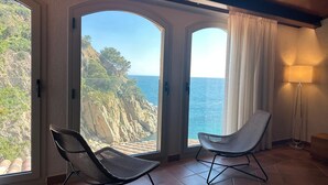 A room with two chairs facing a large window with a coastal view. - Luxury Rocamar – Beachfront & Terrace (Tossa De Mar)