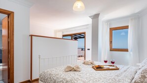 A bedroom with a bed, wooden floor, white walls, a window with curtains, and a balcony view. - 2.Charming Villa Private Pool and sea view (Adeje)