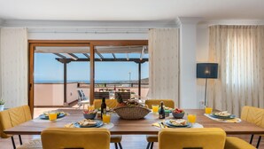 A dining area with a large table, yellow chairs, and a view of the sea. - 2.Charming Villa Private Pool and sea view (Adeje)
