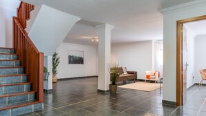 A spacious living area with a wooden staircase, a large potted plant, and a sofa. - 2.Charming Villa Private Pool and sea view (Adeje)