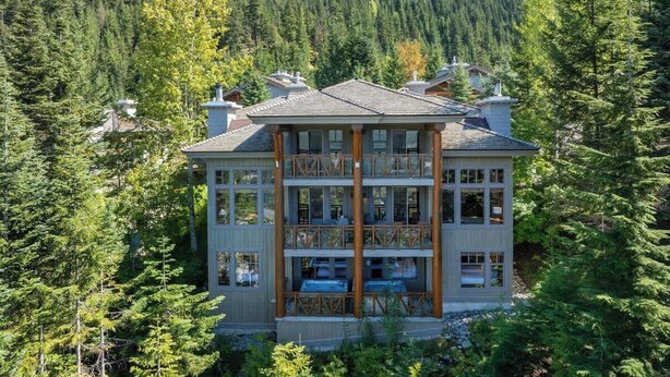 Un edificio de varios pisos rodeado de un bosque frondoso.