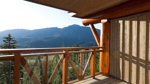 Un balcón de madera con vistas a montañas.