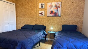A room with two beds, a small table with a lamp, and wooden walls. - New 2 Bed 2Bath Spacious Apartment w/Deck & Parking (Pittsburgh)