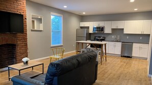 A modern kitchen with white cabinets, a built-in microwave, and a stainless steel refrigerator. - New 2 Bed 2Bath Spacious Apartment w/Deck & Parking (Pittsburgh)