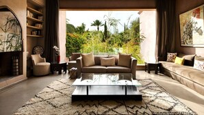 A modern living room with a sofa, coffee table, and bookshelves. - Private Modern Home 11 Rooms, Only 7min city centre (Marrakech)