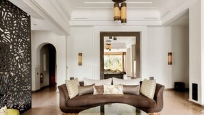 A modern living room with a brown sofa, a glass coffee table, and decorative pillows. - Private Modern Home 11 Rooms, Only 7min city centre (Marrakech)