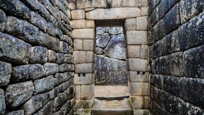 A stone-walled room with a small doorway and steps leading down. - Choquequirao Sanctuary Lodge (Santa Teresa)