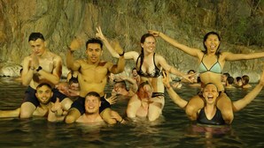 A group of people in a natural setting with water and rocky terrain in the background. - Choquequirao Sanctuary Lodge (Santa Teresa)