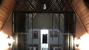 A hotel room with a mirrored entrance, two beds, a small rug, and wall-mounted lights. - Choquequirao Sanctuary Lodge (Santa Teresa)